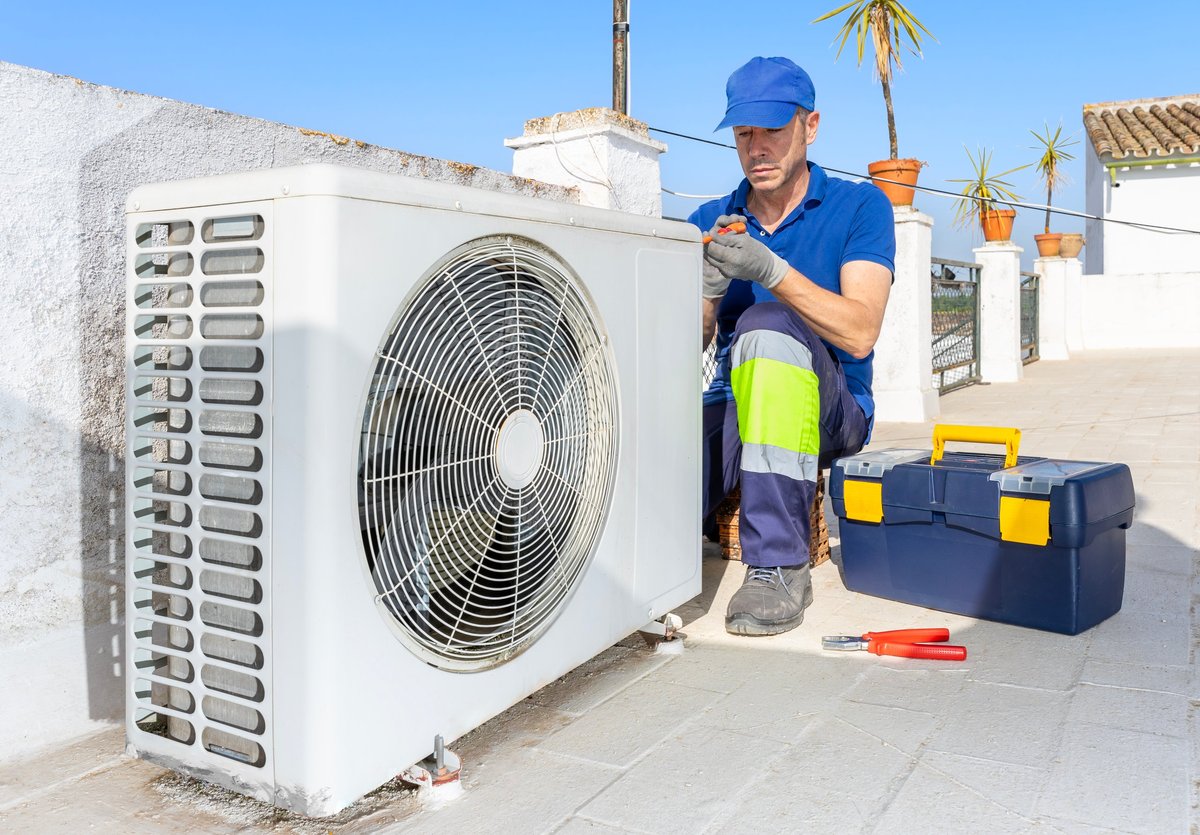 Técnico de HVAC inspeccionando una unidad de aire acondicionado